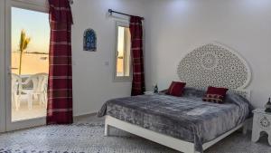 a bedroom with a bed and a table and a window at Djerba Dar Iyad in Mezraya +13 photos