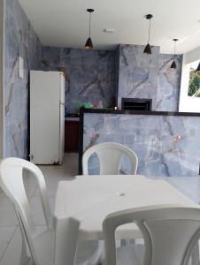 una cucina con un tavolo bianco e sedie bianche di Casa em Búzios 5 a Búzios