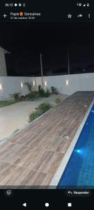 un'immagine di una piscina con uno screenshot di un sito web di Casa em Búzios 5 a Búzios