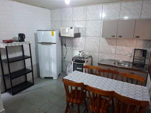 eine Küche mit einem Tisch und einem weißen Kühlschrank in der Unterkunft Giuseppe & Giuseppin in Torres + 16 Fotos