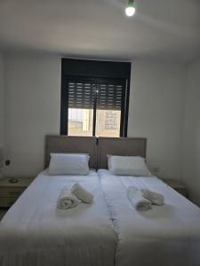 - 2 lits avec serviettes dans une chambre dans l'établissement Neveh Shamir Staycation, à Bet Shemesh