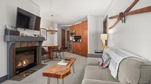un salon avec un canapé et une cheminée dans l'établissement 1302 Lodge At Spruce Peak Ski In Ski Out Two Bedroom By Stowe Mountain Rentals, à Stowe