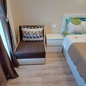 ein kleines Zimmer mit einem Stuhl und einem Bett in der Unterkunft Вила Соната in Achtopol + 22 Fotos