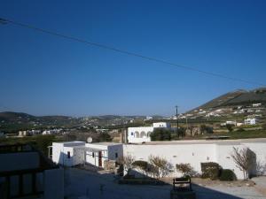 a view of a white building with mountains in the background at Eri Hotel in Parikia