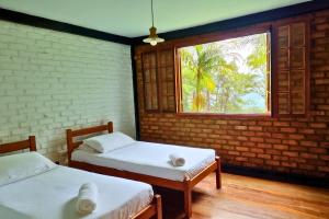 due letti in una stanza con finestra di Rio Habitat - Maria Comprida ad Araras Petropolis