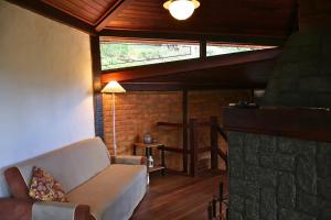 un soggiorno con divano e camino in pietra di Rio Habitat - Maria Comprida ad Araras Petropolis