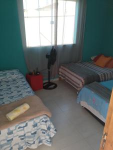 una stanza con due letti e una finestra di Casa em Búzios 5 a Búzios