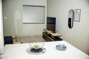 a living room with a table and a television at Villa Ndahafa in Ongwediva