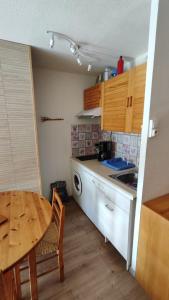 eine Küche mit einem Holztisch, einem Tisch und einem Tisch sowie eine Küche mit in der Unterkunft Family Lodge Grand Tetras Les Angles in Les Angles + 3 Fotos