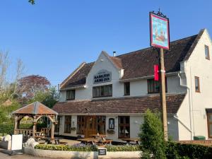 una posada con mesas de picnic delante en Crispins Corner, en Stedham