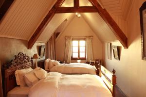 two beds in a room with a attic at Lokanga Boutique Hotel in Antananarivo
