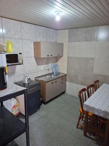 eine kleine Küche mit einem Herd und einem Tisch mit Stühlen in der Unterkunft Giuseppe & Giuseppin in Torres