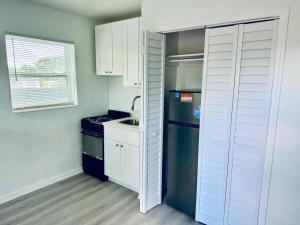 a small kitchen with a refrigerator and a sink at Casa Miami in Miami
