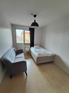 a bedroom with a bed and a chair and a window at Katrineholm Longstay - Fully equipped 3 room apartment in central Katrineholm in Katrineholm