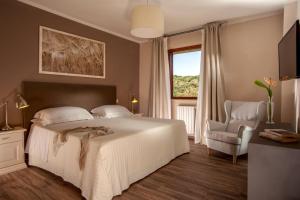 sypialnia z łóżkiem, krzesłem i oknem w obiekcie Valle Del Buttero w mieście Capalbio