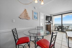 a dining room with a glass table and chairs at Island Sunrise 362 by Youngs Suncoast in Gulf Shores