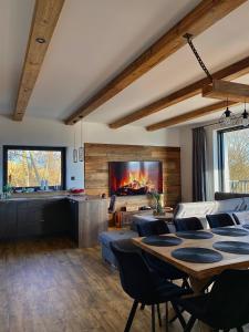 a living room with a table and a fireplace at Chata Wellness Liptov in Ižipovce