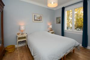 a bedroom with a white bed and a window at Appartement Tarascon avec garage privé in Tarascon