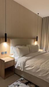 بيات للشقق المخدومة في المدينة المنورة: غرفة نوم بسرير ابيض كبير بها مصباحين