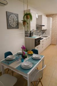 a table in a kitchen with a clock on the wall at Appartamenti Armida in Chioggia