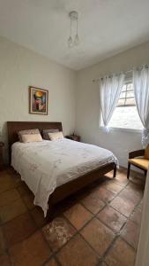 a bedroom with a large bed and a window at Perto da Praia! Apenas 150m, Na melhor região in Ilhabela