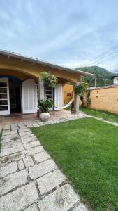 a house with a green lawn in front of it at Perto da Praia! Apenas 150m, Na melhor região in Ilhabela +15 photos
