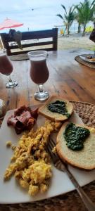 a plate of breakfast food on a table near the beach at Manglar escondido in Mompiche