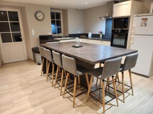 a kitchen with a large wooden table and chairs at Maison de campagne in Restigné
