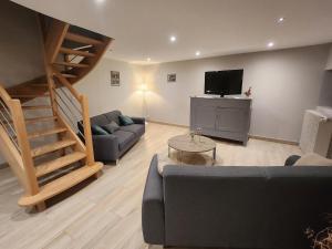 a living room with a couch and a television at Maison de campagne in Restigné