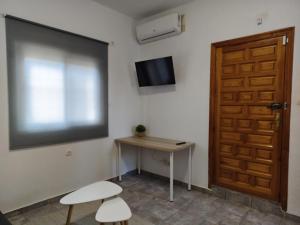 ein Zimmer mit einem Tisch und einem Fernseher und einer Tür in der Unterkunft Apartamento Costacabana in Almería