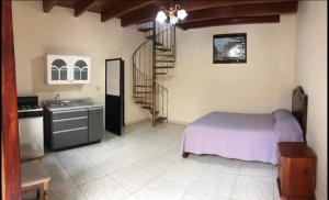 ein Schlafzimmer mit einem Bett, eine Küche und eine Treppe in der Unterkunft Hotel Real de Juarez in Xalapa