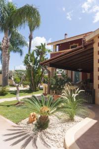 a yard with palm trees and a building at L'Ombra dell'Ulivo B&b in Marsala