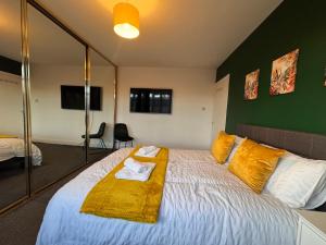 a bedroom with a large white bed with yellow pillows at Kenton Lane in Kenton