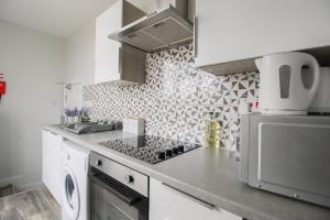 a kitchen with a sink and a stove top oven at Birmingham Central Luxury Suites in Birmingham