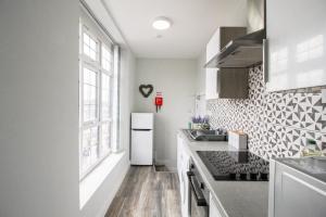 a kitchen with a white refrigerator and a window at Birmingham Central Luxury Suites in Birmingham