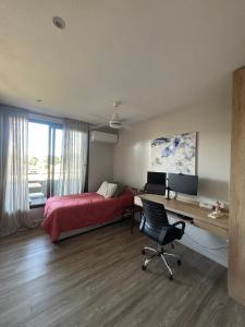 ein Schlafzimmer mit einem Bett, einem Schreibtisch und einem Stuhl in der Unterkunft Departamento con vista al cerro! in Yerba Buena