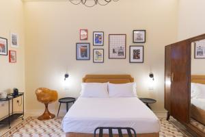 a bedroom with a bed and pictures on the wall at L'Ombra dell'Ulivo B&b in Marsala