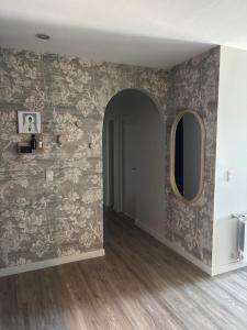 einen Flur mit einer Wand und einem runden Spiegel in der Unterkunft Departamento con vista al cerro! in Yerba Buena + 5 Fotos