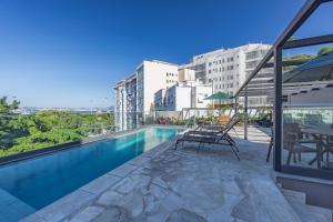 a swimming pool with tables and chairs on a building at Luxo na Gloria in Rio de Janeiro