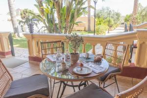 a glass table on a patio with chairs and a table at L'Ombra dell'Ulivo B&b in Marsala