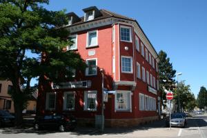 a red building on the corner of a street at Hotel Romäus in Villingen-Schwenningen
