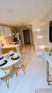 a kitchen and living room with a table and chairs at Linda casa em Garanhuns-PE in Garanhuns
