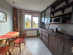 a kitchen with a table and a table and chairs at Apartamentai 78 in Mažeikiai
