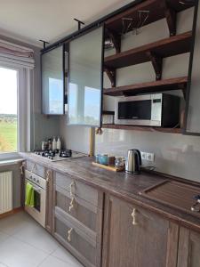 a kitchen with wooden cabinets and a counter top at Apartamentai 78 in Mažeikiai +6 photos