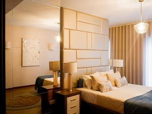 une chambre d'hôtel avec un lit et un miroir dans l'établissement Luxury 2BR Spacious & Stylish with Patio near Metro, à Odivelas