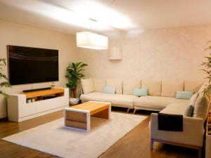 un salon avec un canapé et une télévision à écran plat dans l'établissement Luxury 2BR Spacious & Stylish with Patio near Metro, à Odivelas