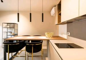 a kitchen with a wooden table and black chairs at LagoC0C00N - Colazione - 300m stazione - 800m lago in Desenzano del Garda +21 photos
