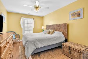 ein Schlafzimmer mit einem Bett und einem Deckenventilator in der Unterkunft Seashell Cottage by Oak Island Accommodations in Oak Island + 121 Fotos