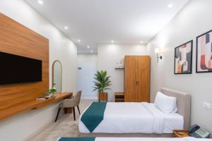 a bedroom with a bed and a desk and a tv at Seven Stays New Cairo in Cairo