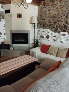 a living room with two beds and a stone fireplace at Rincón del Bierzo in Borrenes